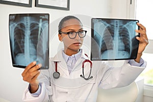 Portrait of confident female doctor examining x-ray pictures