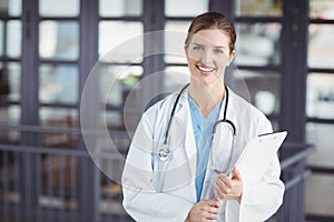 Portrait of confident female doctor holding clipboard