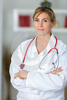 Portrait confident female doctor standing arms crossed in clinic