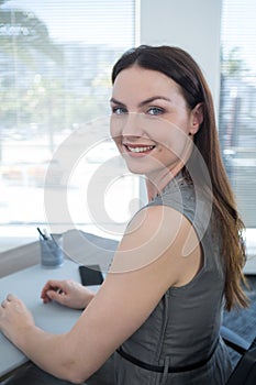 Portrait of confident female executive sitting at desk