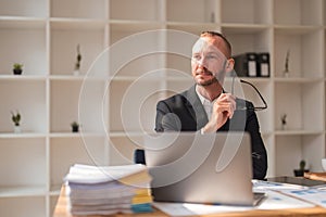 Portrait of a confident and focused businessman with a laptop Working document, graph and plans At the desk in the