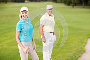 Portrait of confident golfer couple