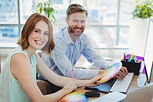 Portrait of confident graphic designers working at desk