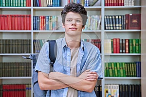 Portrait of confident guy college student looking at camera inside library