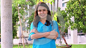 Portrait of a confident, happy, and smiling Asian medical woman doctor or nurse wearing blue scrubs uniform