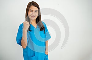 Portrait Of confident, happy, and smiling Asian medical woman doctor or nurse wearing blue scrubs uniform over isolated white