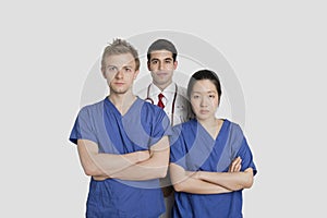 Portrait of confident healthcare workers standing over gray background