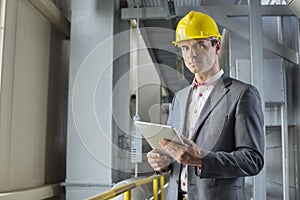 Portrait of confident male architect holding digital tablet in industry