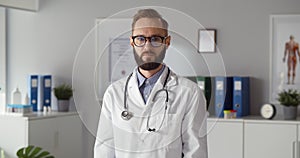 Portrait of confident male doctor putting stethoscope around neck looking at camera