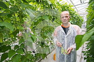 Portrait of confident male researcher holding green beans while