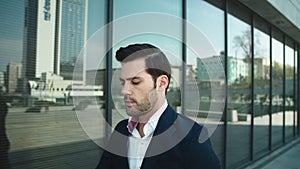 Portrait man walking near building. Businessman walking up stairs outdoors