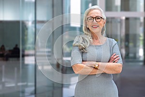 Portrait of a confident mature business person standing outside office workspace, bank, financial institution