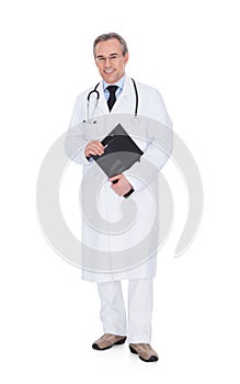 Portrait Of Confident Mature Doctor Holding Clipboard