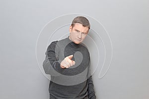 Portrait of confident mature man pointing with index finger at you