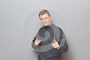 Portrait of confident mature man pointing with index fingers at you