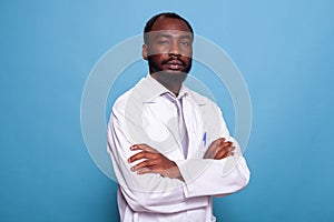 Portrait of confident medical doctor in white lab coat on blue background