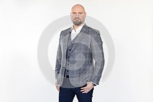 Portrait of confident middle-aged businessman in grey checkered jacket, vest, blue jeans, white shirt, standing, posing.