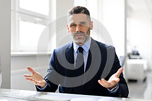 Portrait of confident middle aged businessman having virtual online meeting, talking and gesturing to camera