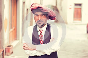 Portrait of a confident middle aged man standing outdoors on a street of an old village