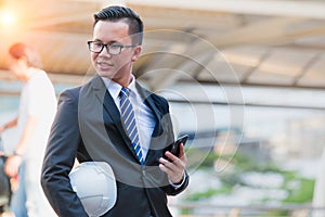 Portrait of confident modern young businessman wear black suit hand holding digital tablet.