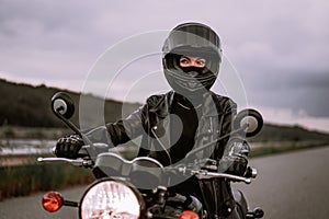 Ritratto fiducioso motociclista una donna motociclo casco. giovane autista cercando lontano al di fuori sul autostrada 