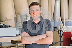 Portrait of confident owner of industrial small business carpenters workshop, man with folded hands