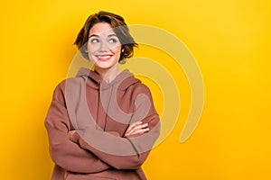Portrait of confident person cheerful lady look side space hold crossed arms wear brown hood shirt isolated yellow color