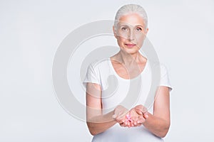 Portrait of confident person holding hand with pink ribbon wearing trendy t-shirt isolated over white background