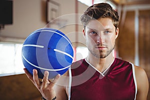 Portrait of confident player holding basketball