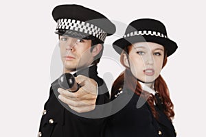 Portrait of confident police officers against gray background