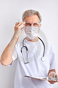 Portrait of confident senior doctor man adjusting goggles