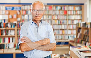 Portrait of confident senior man in interior of modern bookstore