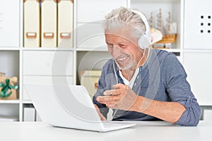 Portrait of confident senior man using laptop
