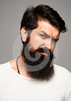 Portrait of confident serious man has beard and mustache, looks seriously, isolated. Hipster guy models in studio