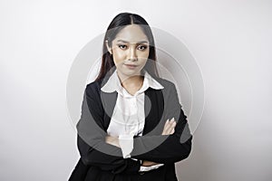 Portrait of a confident smiling Asian girl boss wearing black suit standing with arms folded and looking at the camera isolated