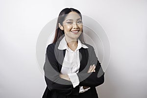 Portrait of a confident smiling Asian girl boss wearing black suit standing with arms folded and looking at the camera isolated