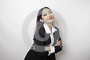 Portrait of a confident smiling Asian girl boss wearing black suit standing with arms folded and looking at the camera isolated