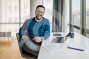 Portrait of confident smiling entrepreneur with laptop computer