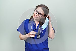 Portrait of confident smiling female doctor with stethoscope in blue uniform