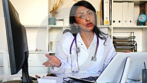 Portrait of confident smiling female doctor in white lab coat standing in modern medical office