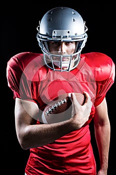 Portrait of confident sportsman holding American football