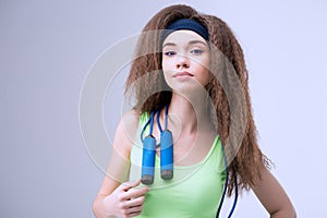 Portrait of confident sporty woman with skipping rope