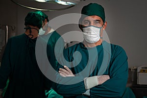 Portrait of confident surgical team leader in sterile operating room.