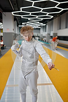 Portrait of confident teenage boy fencer with sharp sword