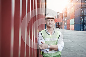 Portrait, Confident Transport Engineer Man in Safety Equipment Standing in Container Ship Yard. Transportation Engineering