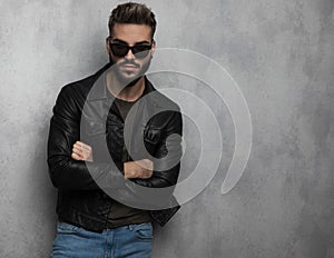 Portrait of confident unshaved man wearing leather jacket and sunglasses