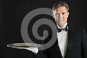 Portrait Of Confident Waiter Carrying Serving Tray