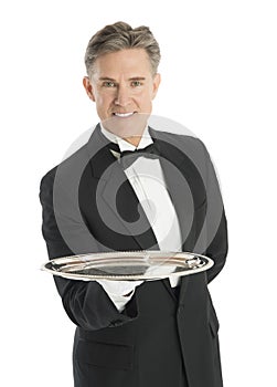 Portrait Of Confident Waiter In Tuxedo Carrying Serving Tray