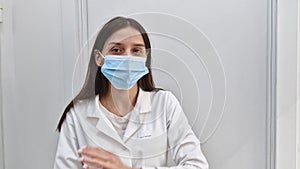 Portrait of confident woman healthcare worker wearing medical face mask for disease protection. Professional female nurse