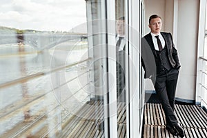 Portrait of confident young businessman standing at hotel balcony